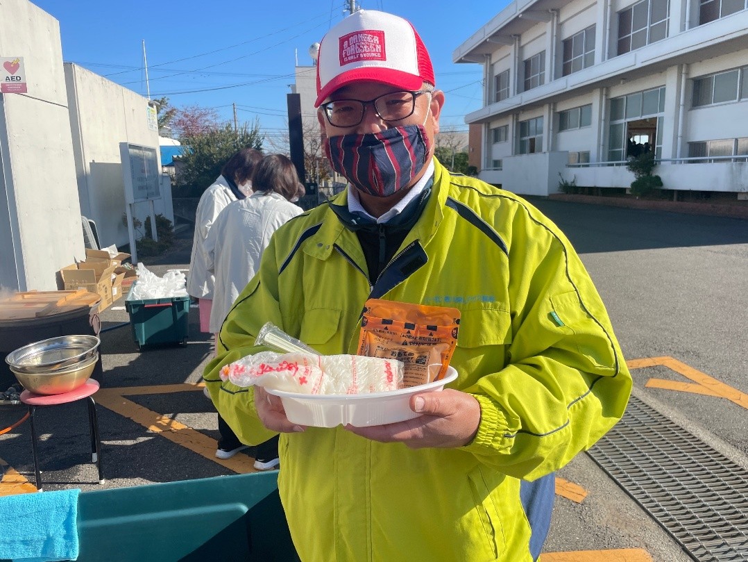 ご飯とカレーのセットを持つ香川県LPガス協会山﨑さん
